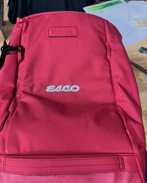 ESCO logo embroidered in white on a red YETI backpack