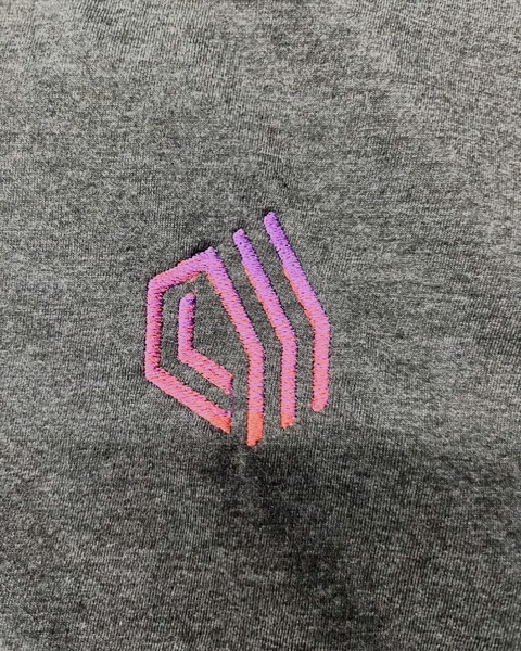 Geometric logo embroidered in a pink-to-purple color blend on a charcoal heather shirt