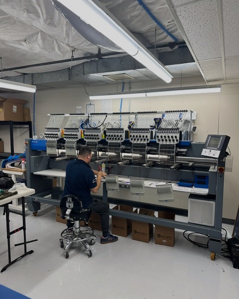 Serena Embroidery operator setting up a multi-head ZSK embroidery machine at the Lake Oswego shop